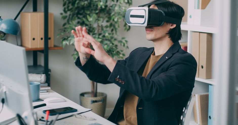 Hombre en un entorno de oficina usando un visor de realidad virtual para desarrollar contenido interactivo