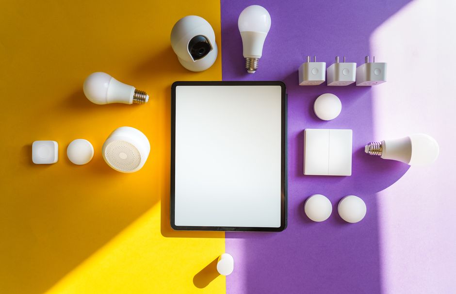 Vista superior de dispositivos inteligentes y tablet sobre fondo dividido amarillo y morado